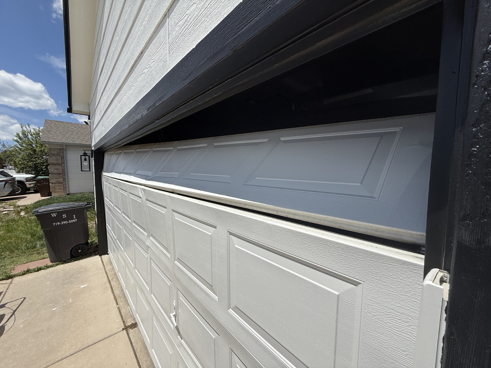 Damaged garage door requiring professional repair